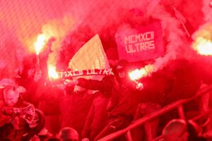 Újpest-szurkolók pirotechnikával a lelátón.