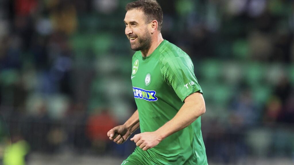 Böde Dániel mosolyogva fut a pályán zöld mezben.