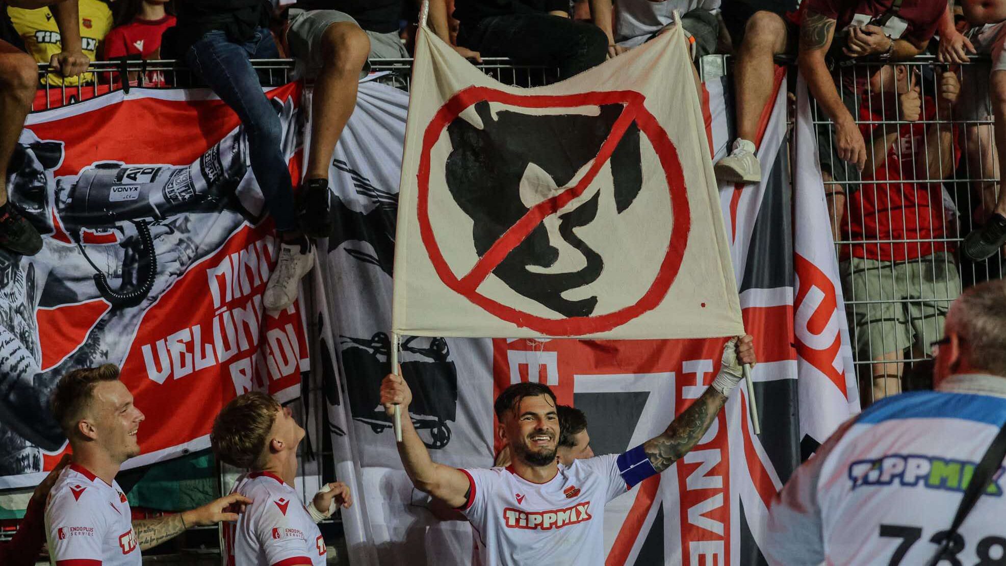 Hangya Szilveszter egy RBD-ördögfejet áthúzva ábrázoló kétrudas zászlóval