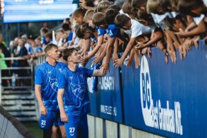 ZTE-játékosok kezet fognak a szurkolókkal a lelátónál.